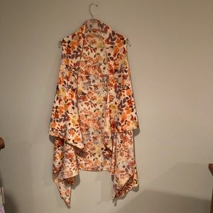 Floral tunic shown with a couple of shirts. 100% polyester, one size fits all